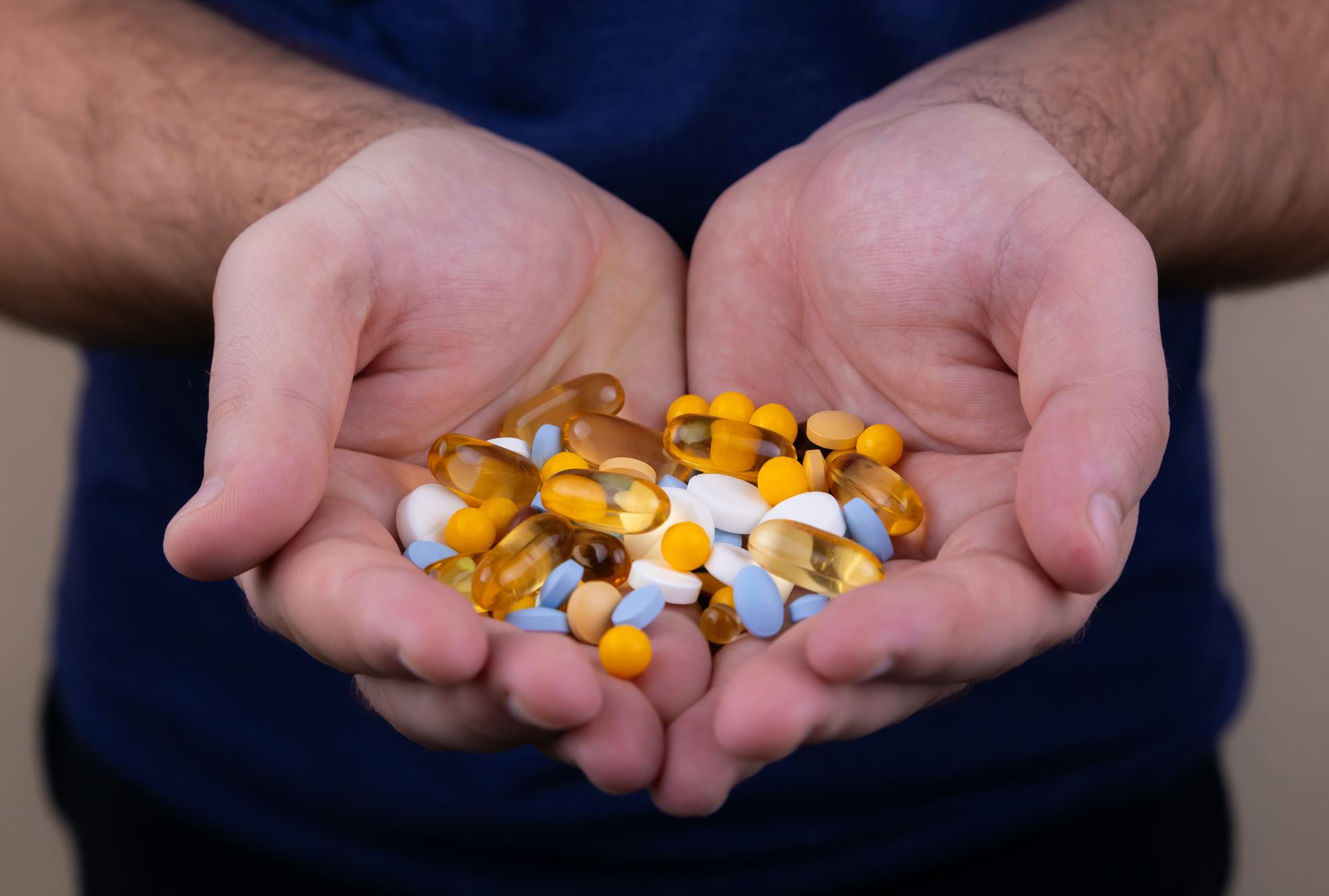 a person holding a pile of pills in there hand