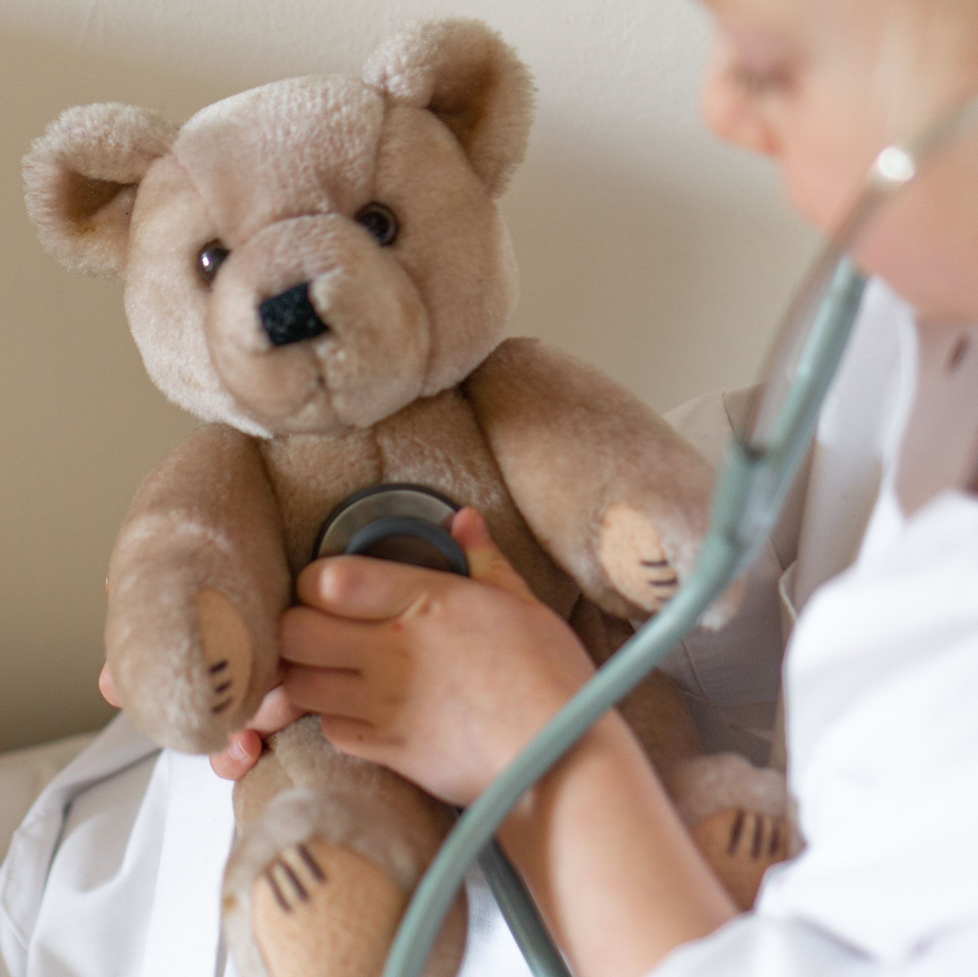 a child with a teddy bear using a stethoscope